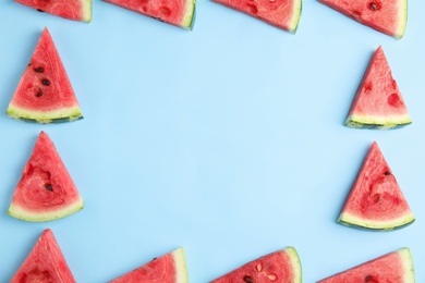 Photo of Frame made with slices of ripe watermelon on light blue background, flat lay. Space for text