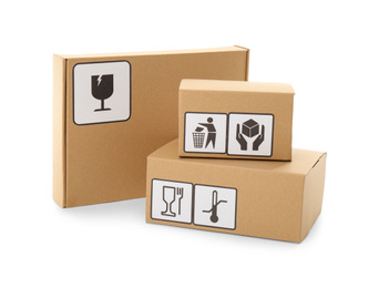 Photo of Cardboard boxes with different packaging symbols on white background. Parcel delivery