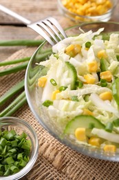 Photo of Tasty salad with Chinese cabbage, corn and cucumber in bowl on table, closeup