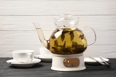 Photo of Teapot with hot aromatic tea on table