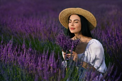 Beautiful young woman with bouquet in lavender field