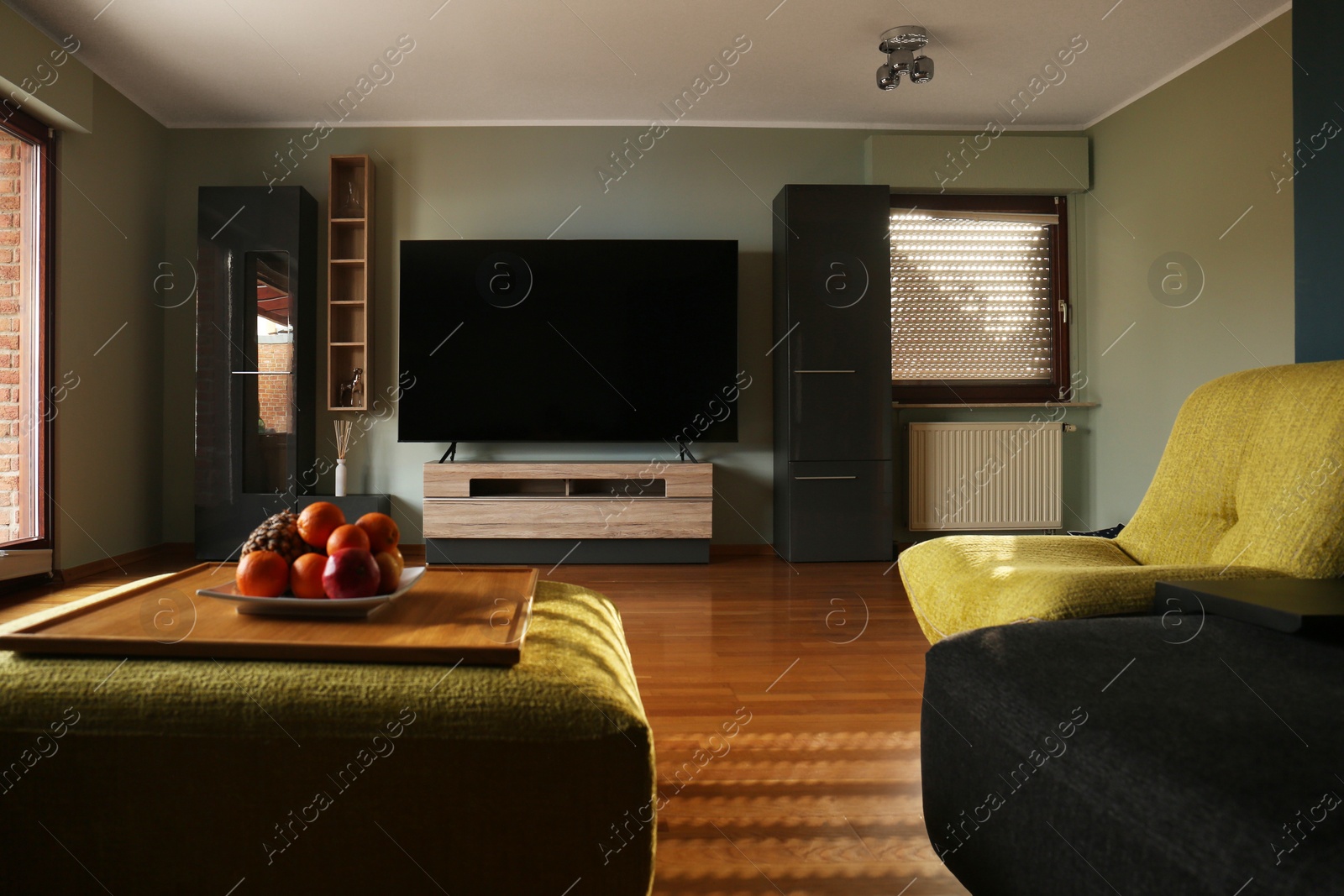 Photo of Stylish room with beautiful furniture and TV set on table. Interior design