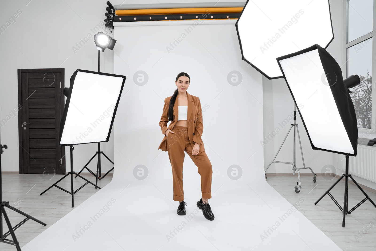 Photo of Beautiful young model posing in modern studio. Professional photo session