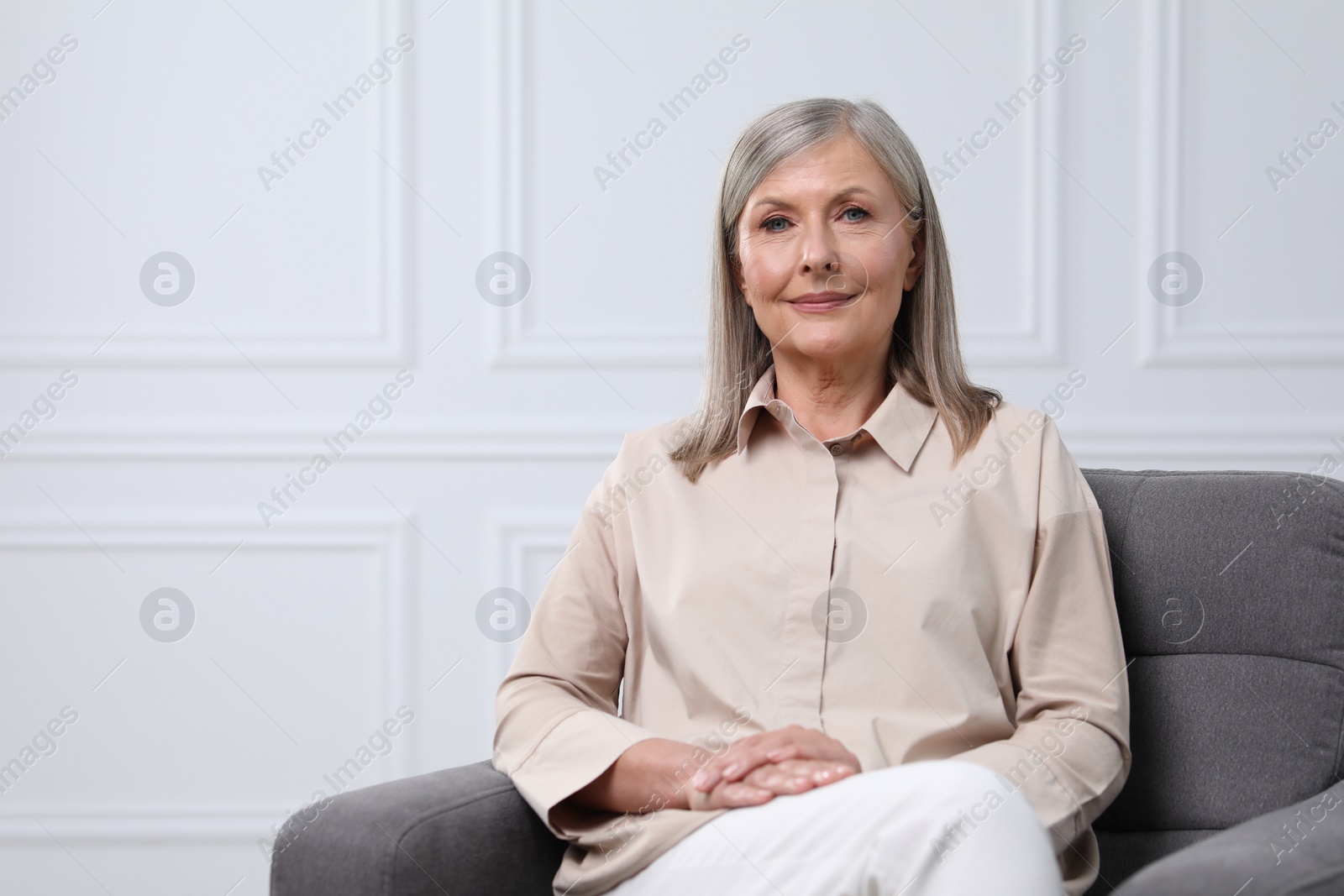 Photo of Portrait of beautiful senior woman in armchair indoors. Space for text