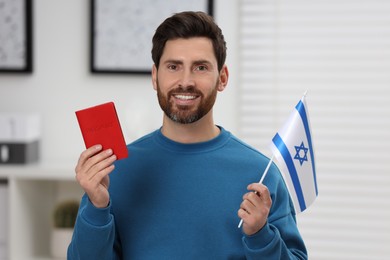 Photo of Immigration. Happy man with passport and flag of Israel indoors
