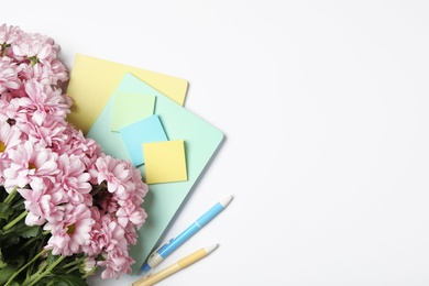 Photo of Flowers and stationery on white background, flat lay with space for text. Teacher's Day