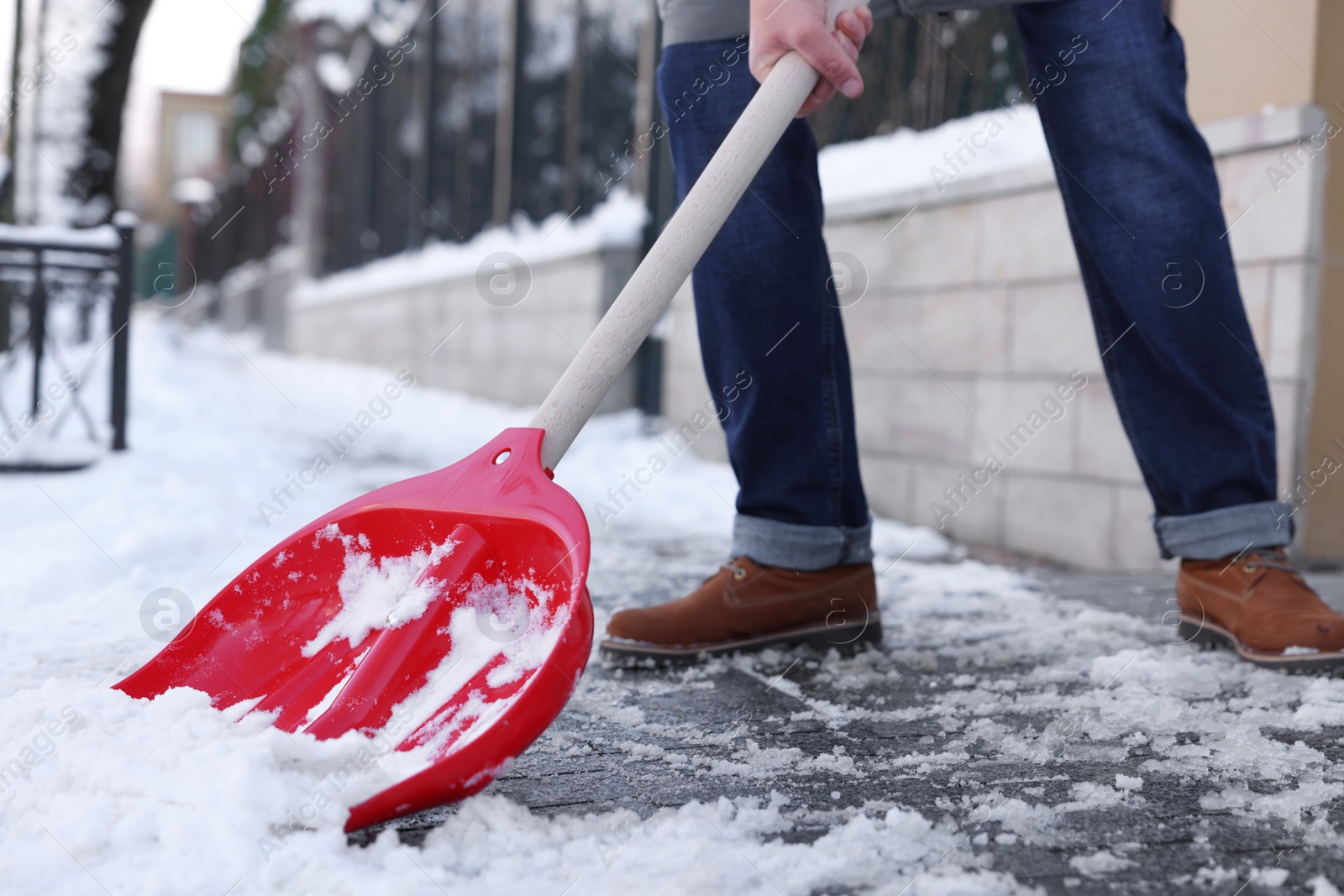 Photo of Man shoveling snow on city street, closeup