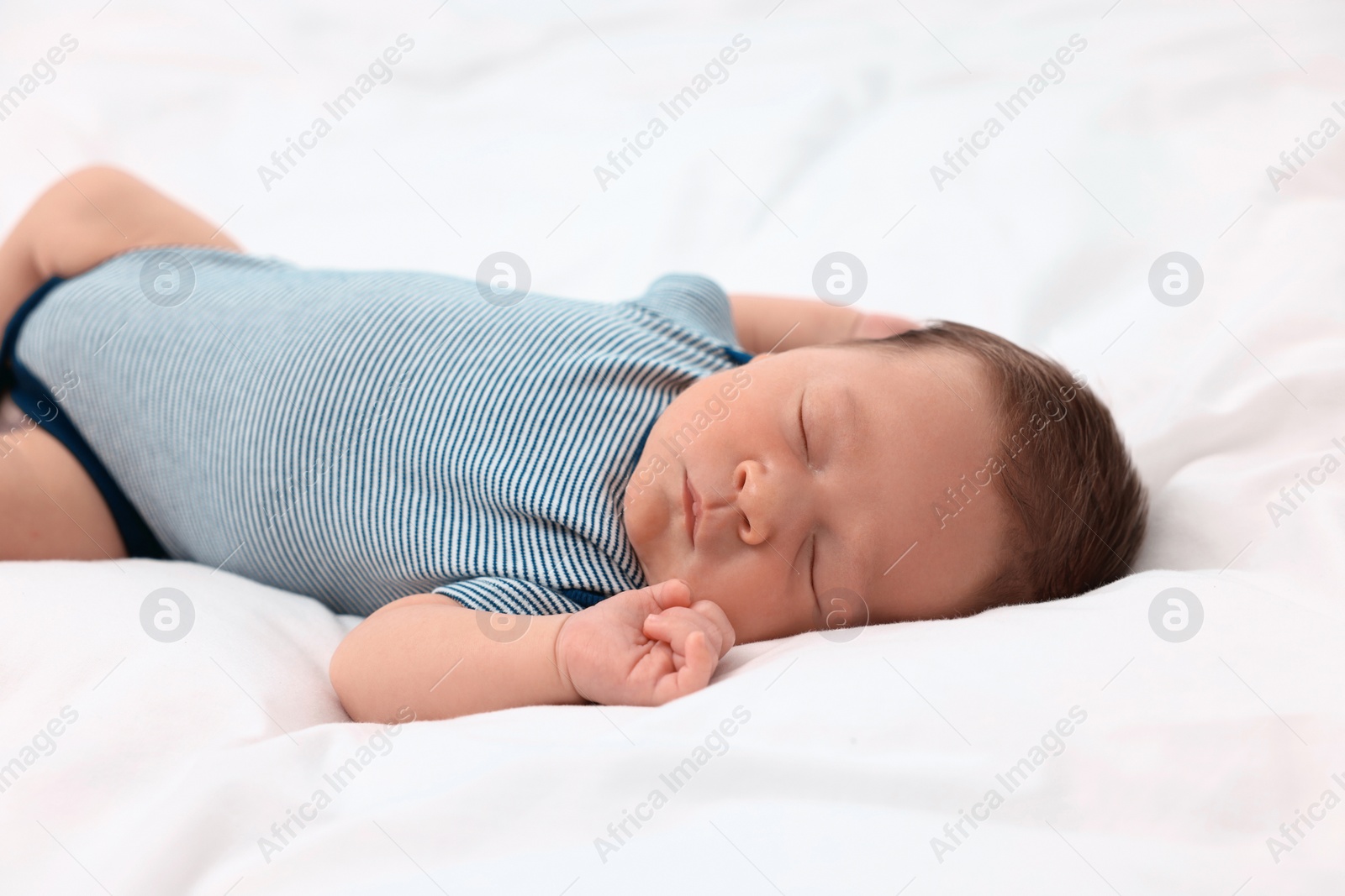 Photo of Cute newborn baby sleeping on white soft bed