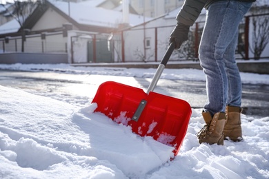 Person shoveling snow outdoors on winter day, closeup