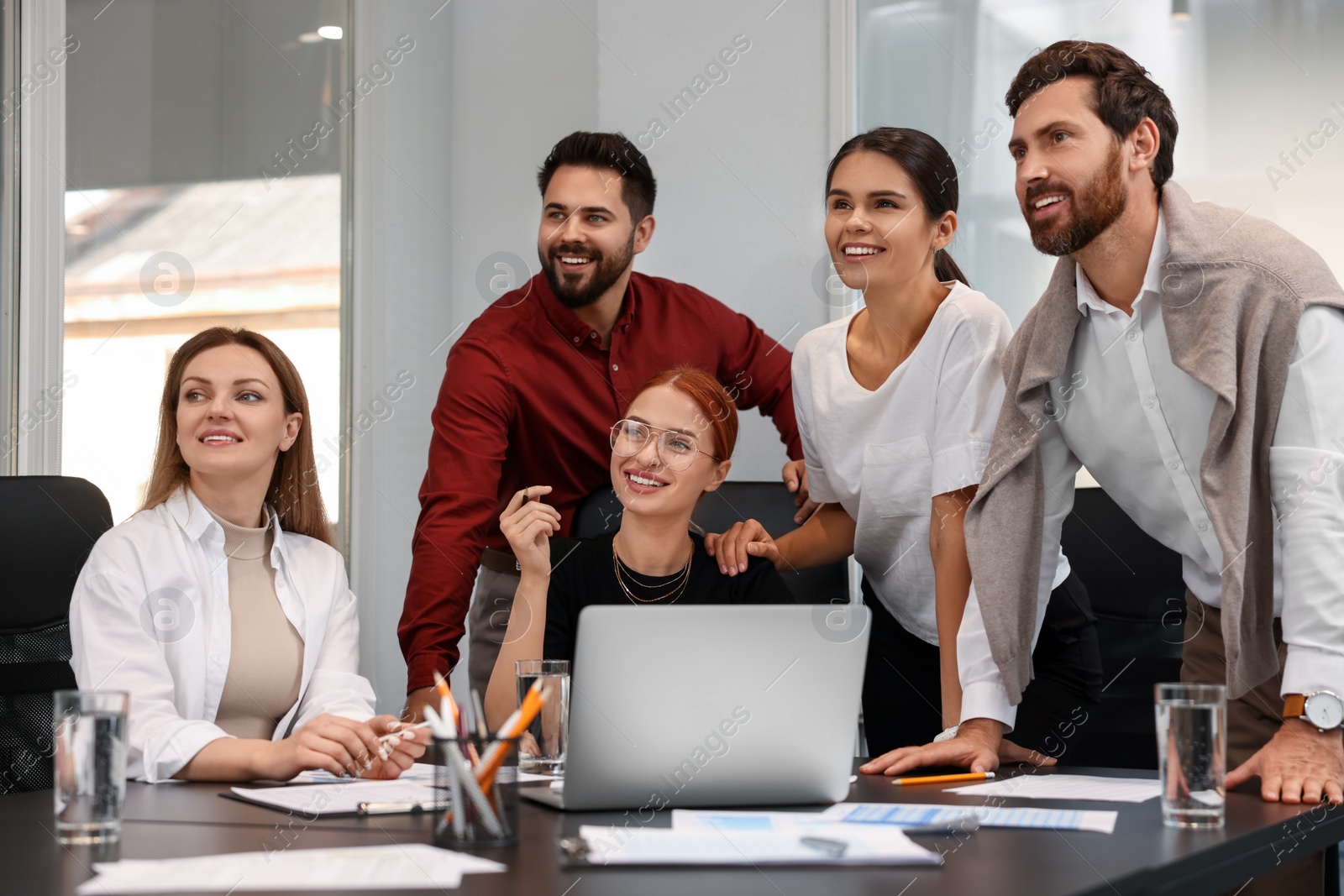 Photo of Team of employees working together in office