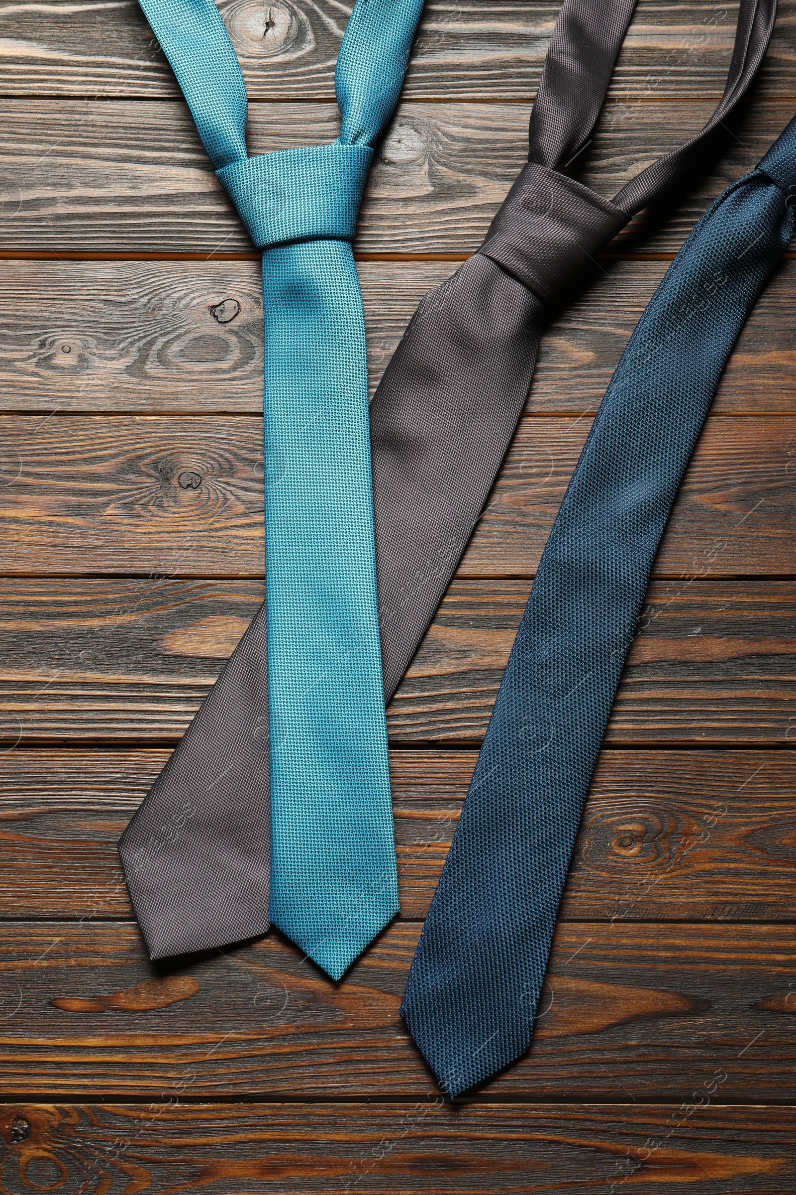 Photo of Different neckties on wooden table, flat lay