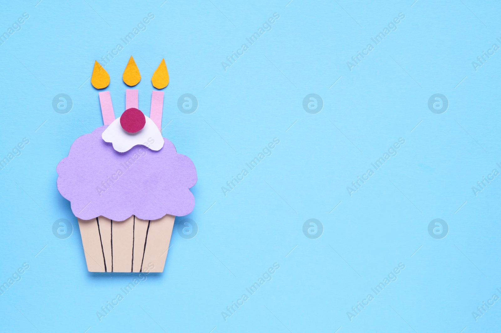 Photo of Birthday party. Paper cupcake on light blue background, top view with space for text