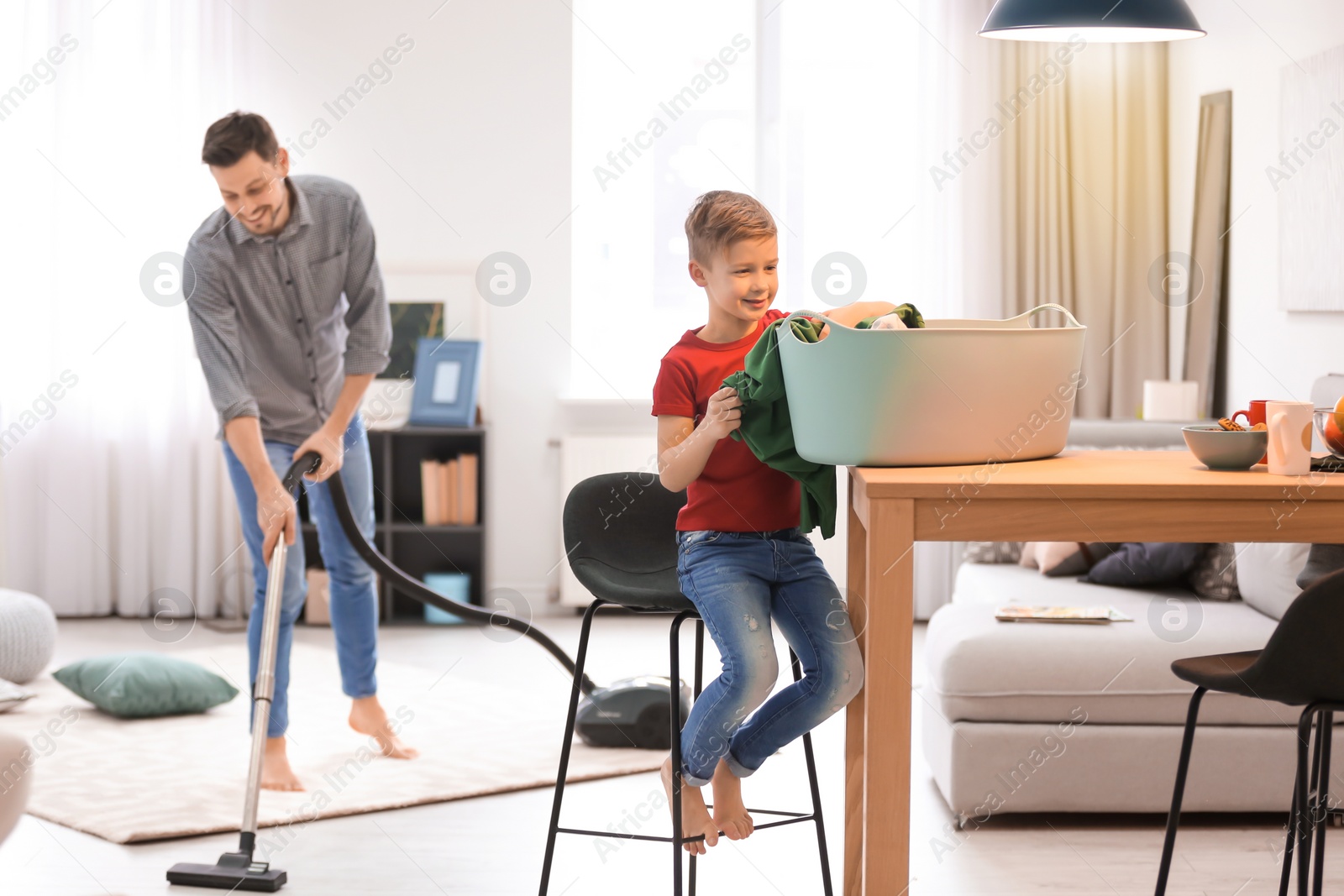 Photo of Little boy and his dad cleaning their house together