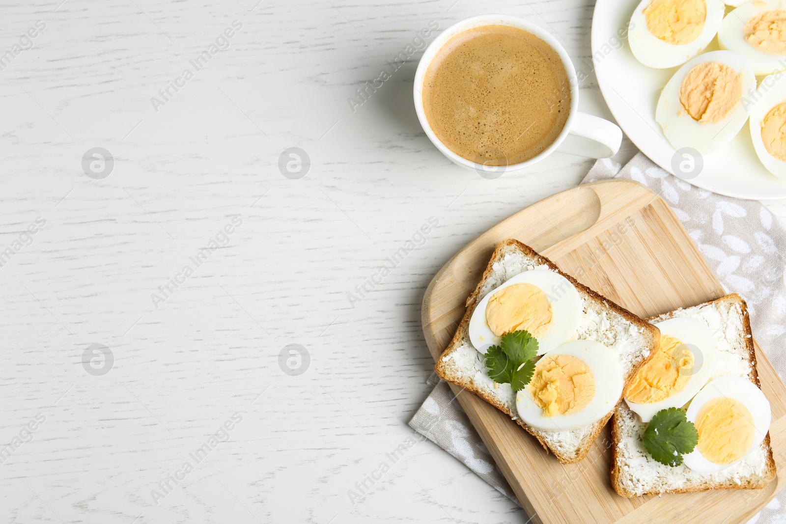 Photo of Tasty egg sandwiches served with coffee on white wooden table, flat lay. Space for text