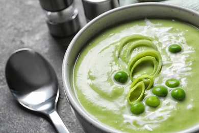 Photo of Fresh vegetable detox soup made of green peas in dish on table, closeup