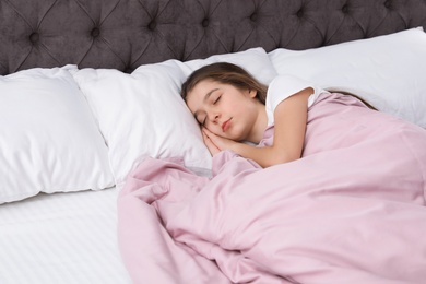 Photo of Beautiful little girl sleeping in bed. Space for text