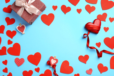 Photo of Flat lay composition with red hearts and gift on light blue background. Space for text