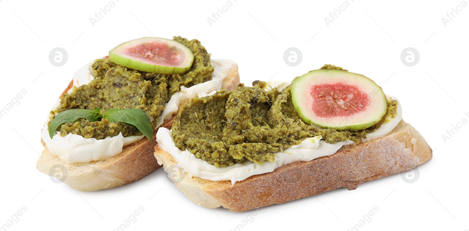 Photo of Tasty bruschettas with cream cheese, pesto sauce, fig and fresh basil on white background