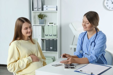 Photo of Happy pregnant woman having doctor appointment in hospital