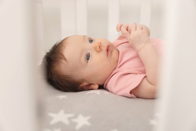 Getting ready for bed. Cute little baby lying in crib