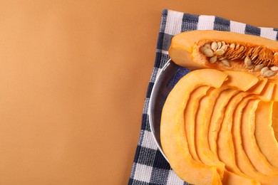 Photo of Slices of fresh ripe pumpkin on orange background, top view. Space for text