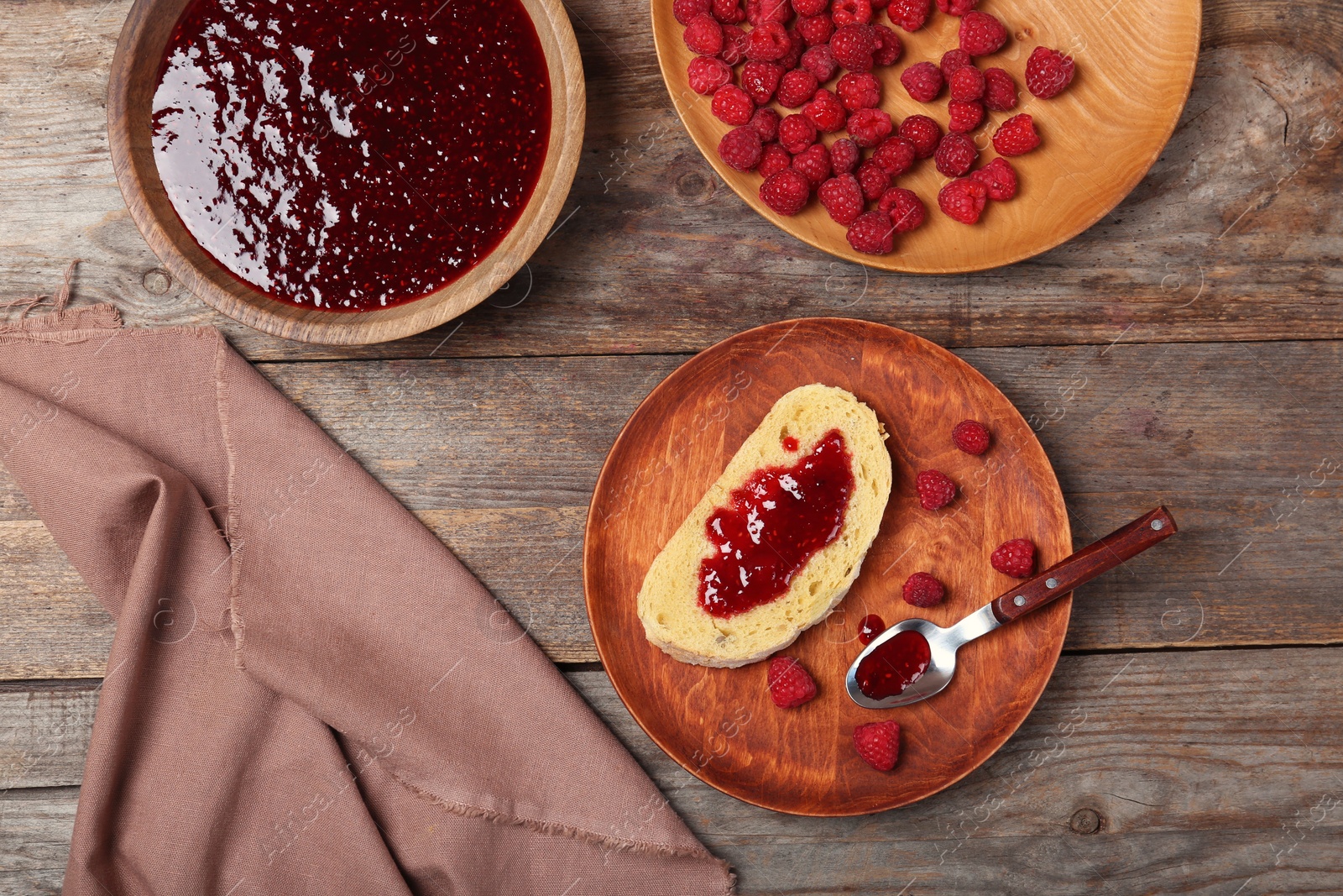 Photo of Beautiful composition with delicious raspberry jam on wooden table, top view