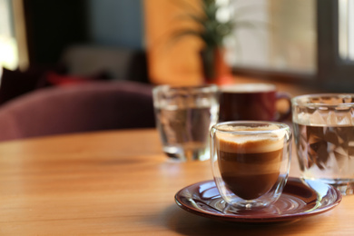 Aromatic coffee on wooden table in cafe. Space for text