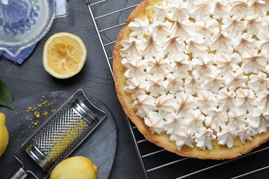 Photo of Flat lay composition with delicious lemon meringue pie on black table