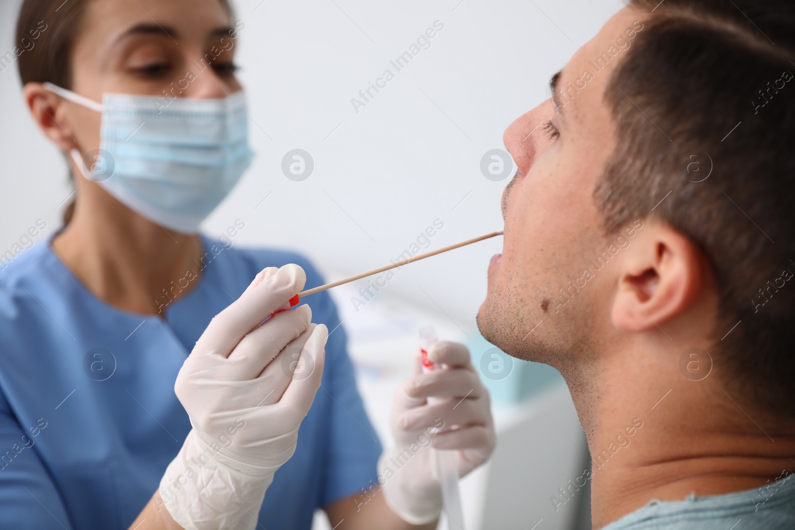 Photo of Doctor taking sample for DNA test from man in clinic