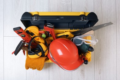 Photo of Box with professional tools for repair on white wooden table, top view