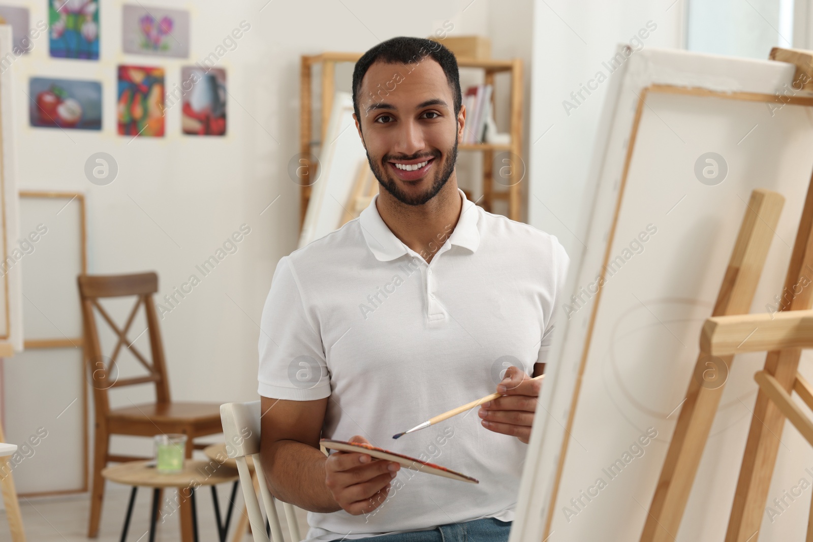 Photo of Young man painting in studio. Creative hobby