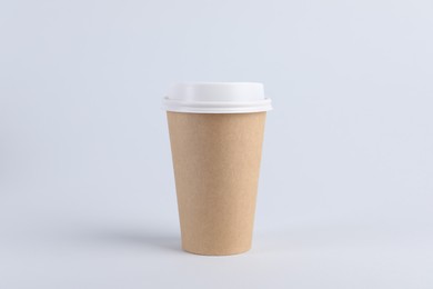 Paper cup with plastic lid on light background. Coffee to go