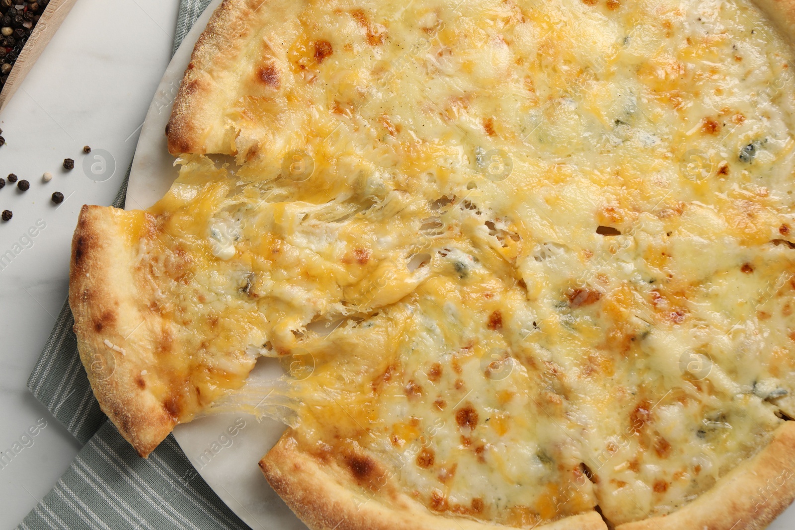 Photo of Delicious cut cheese pizza on white table, top view