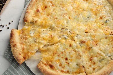 Photo of Delicious cut cheese pizza on white table, top view