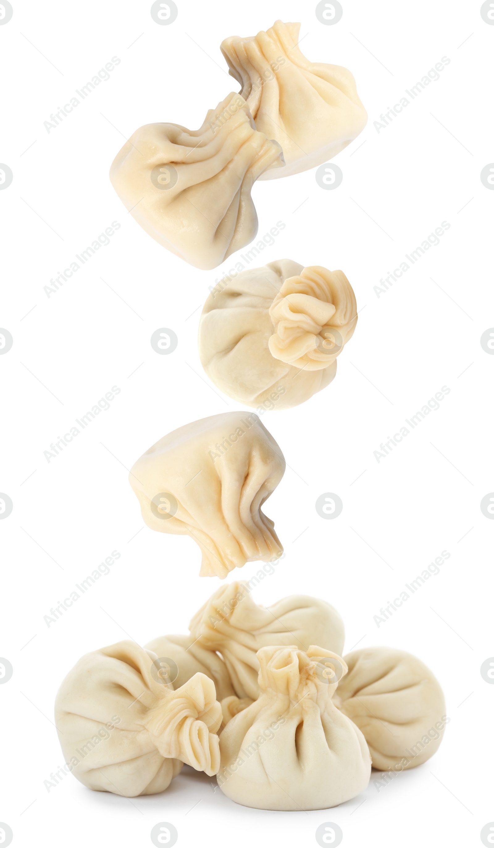 Image of Many tasty dumplings falling on white background