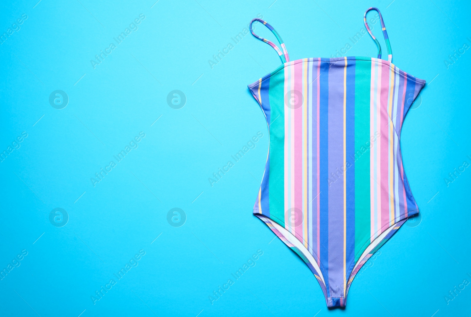 Photo of One-piece swimsuit on color background, top view