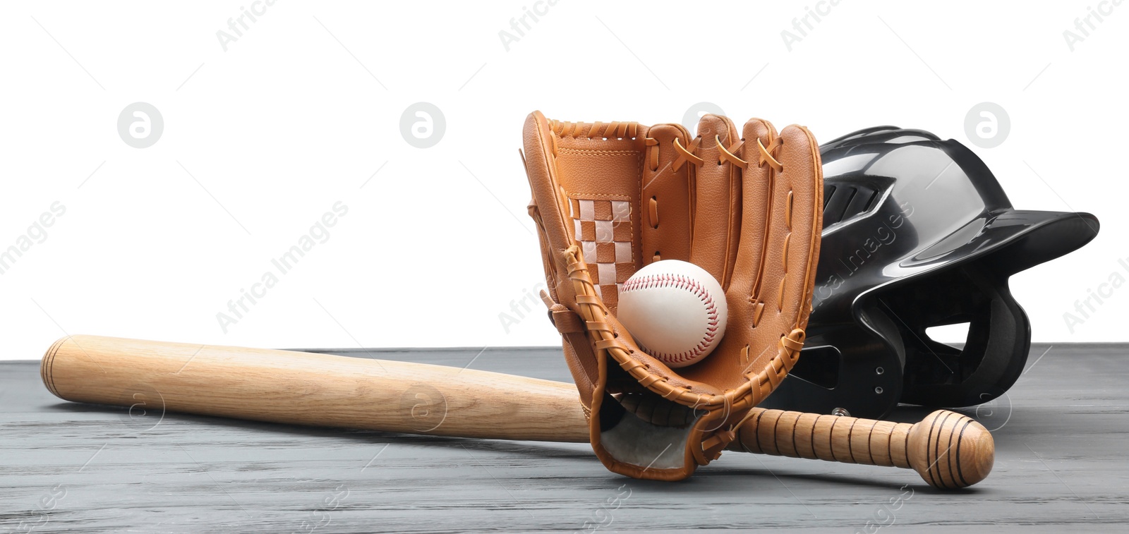 Photo of Baseball glove, bat, ball and batting helmet on grey wooden table against white background