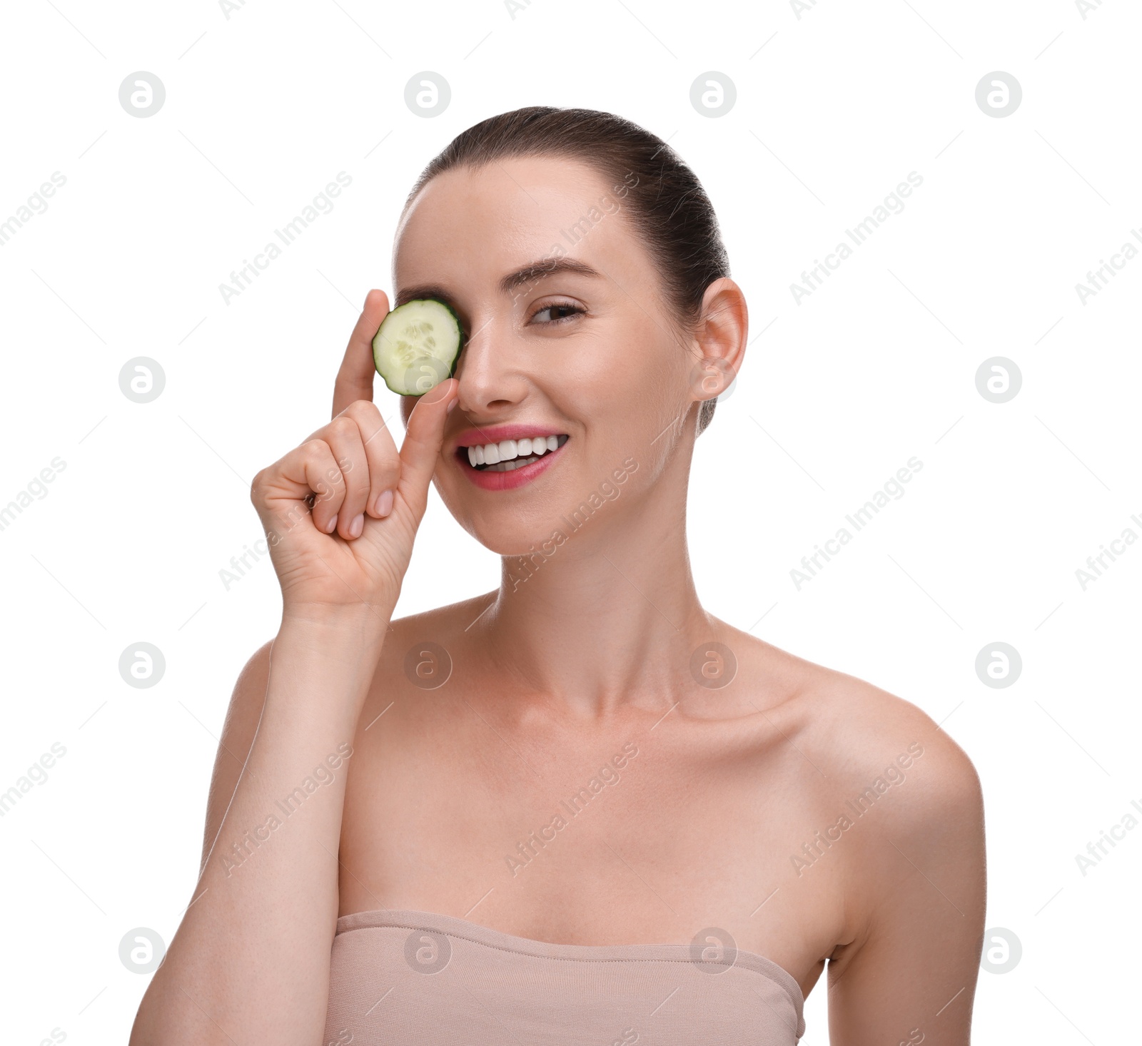 Photo of Beautiful woman covering eye with piece of cucumber on white background