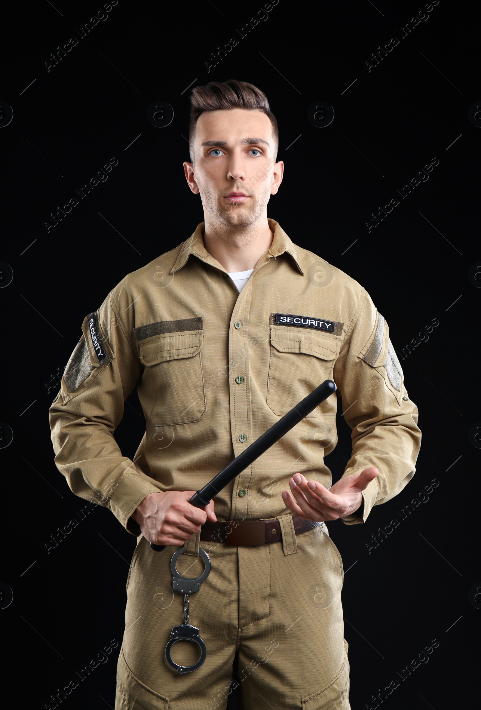 Photo of Male security guard with police baton on dark background