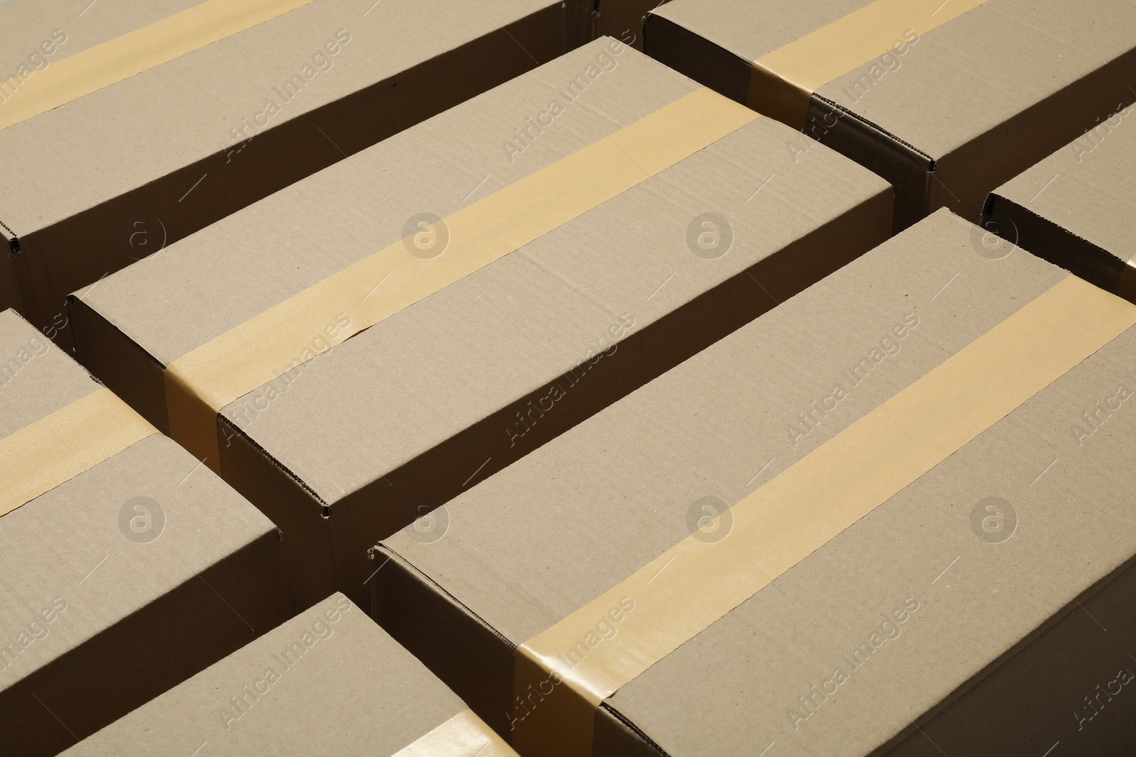 Photo of Many closed cardboard boxes with tape as background