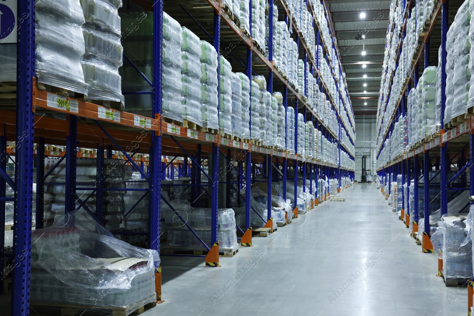 Photo of Warehouse interior with metal racks full of merchandise. Wholesale business