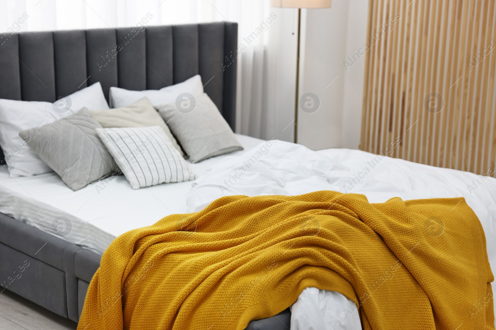 Photo of Soft plaid and pillows on bed in bedroom