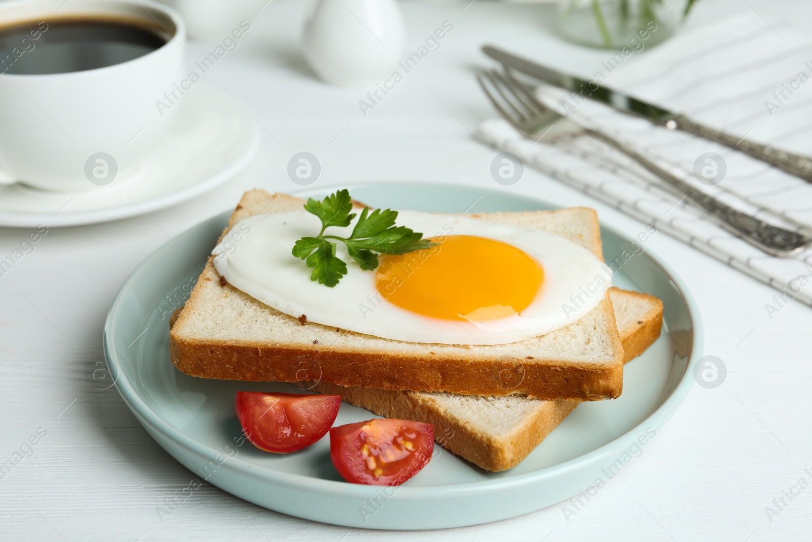 Photo of Tasty fried egg with bread and tomato on white wooden table