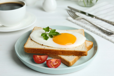 Photo of Tasty fried egg with bread and tomato on white wooden table
