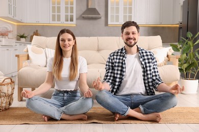 Photo of Couple meditating together at home. Harmony and zen