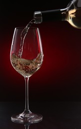 Photo of Pouring white wine from bottle into glass on color background