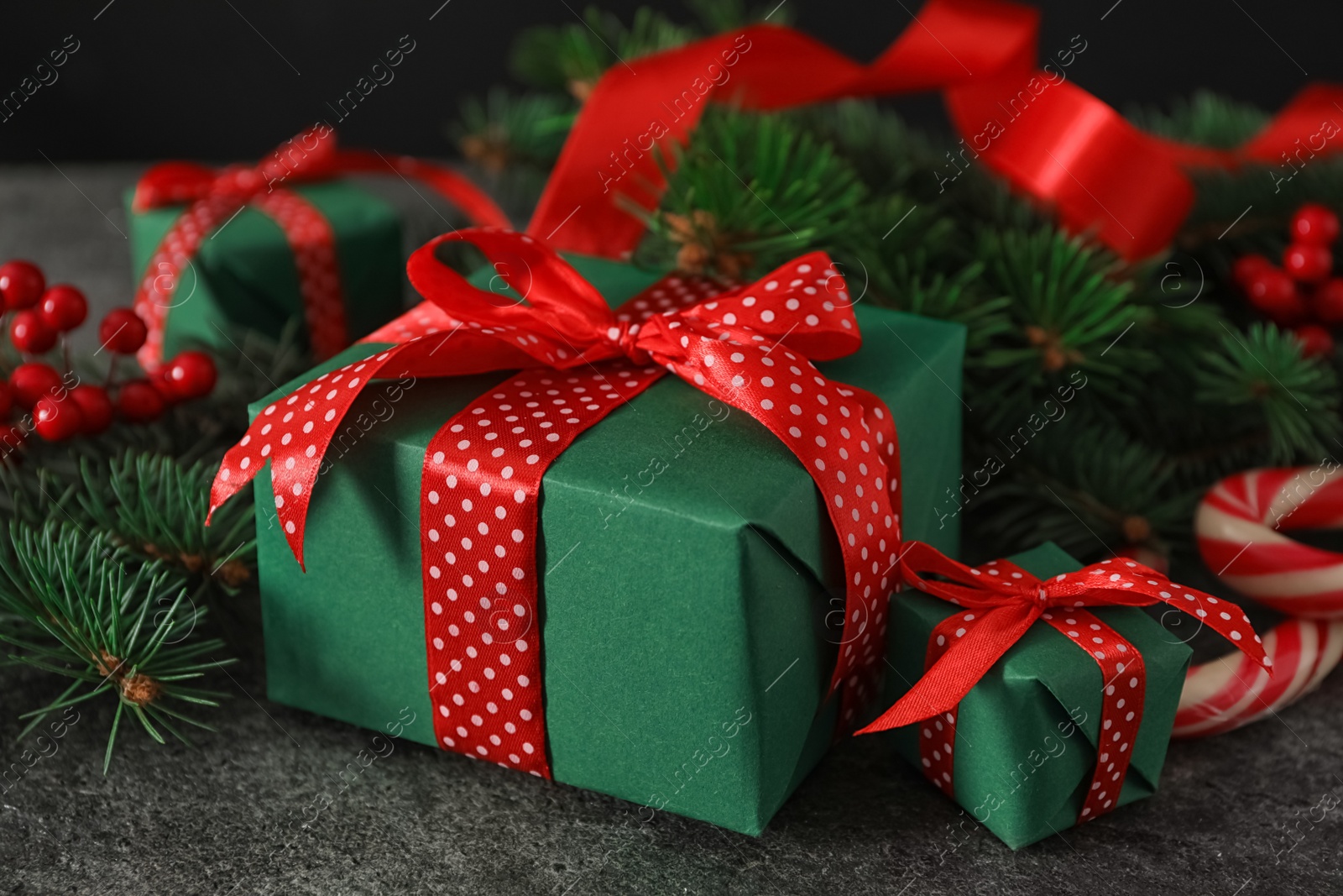 Photo of Green Christmas gift boxes with red bows on grey table