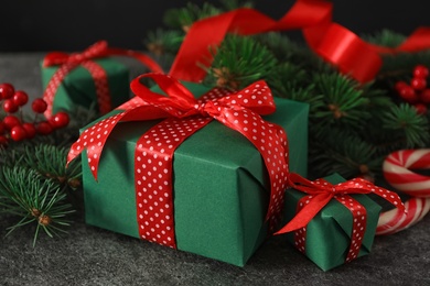 Photo of Green Christmas gift boxes with red bows on grey table