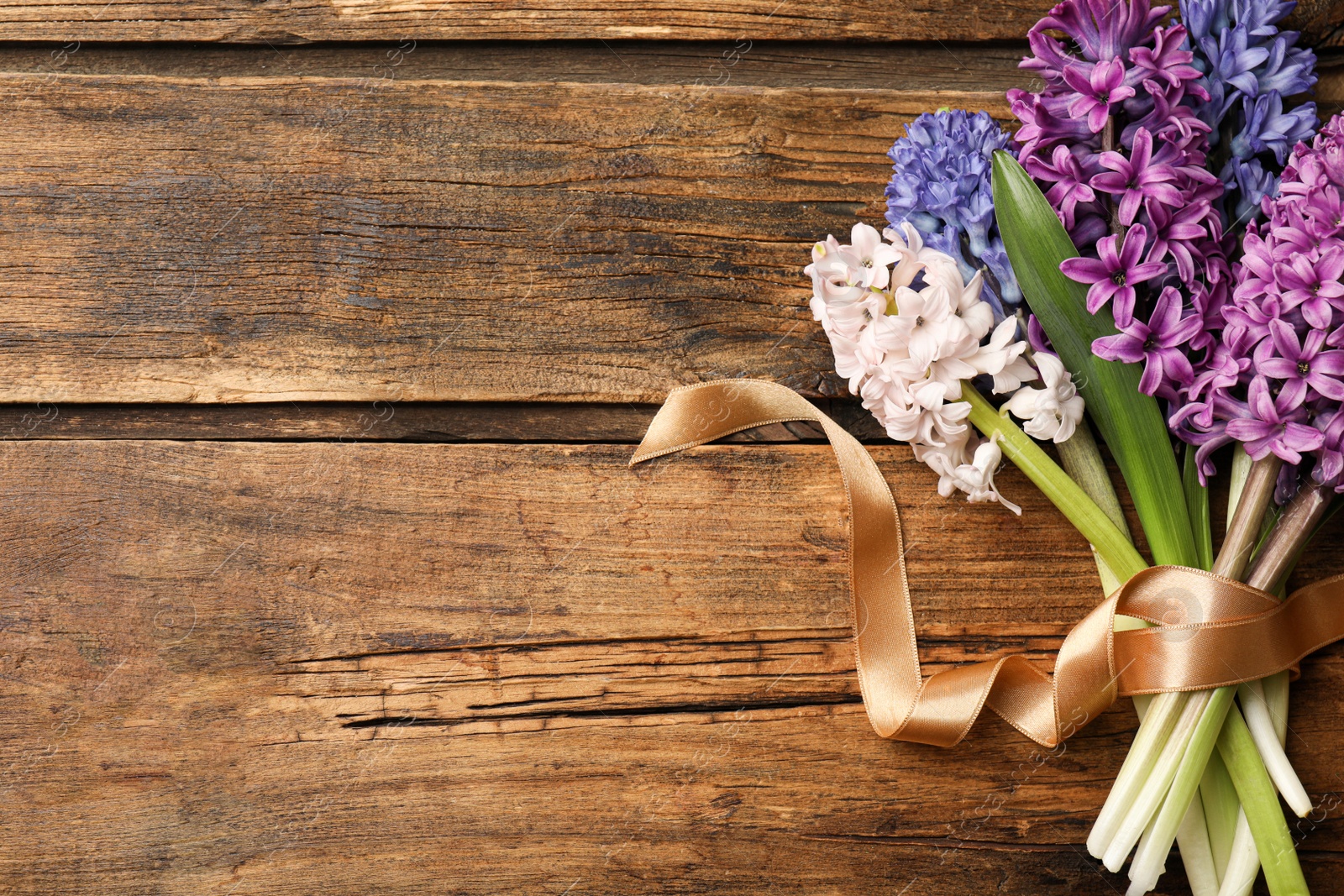 Photo of Beautiful spring hyacinth flowers on wooden table, top view. Space for text