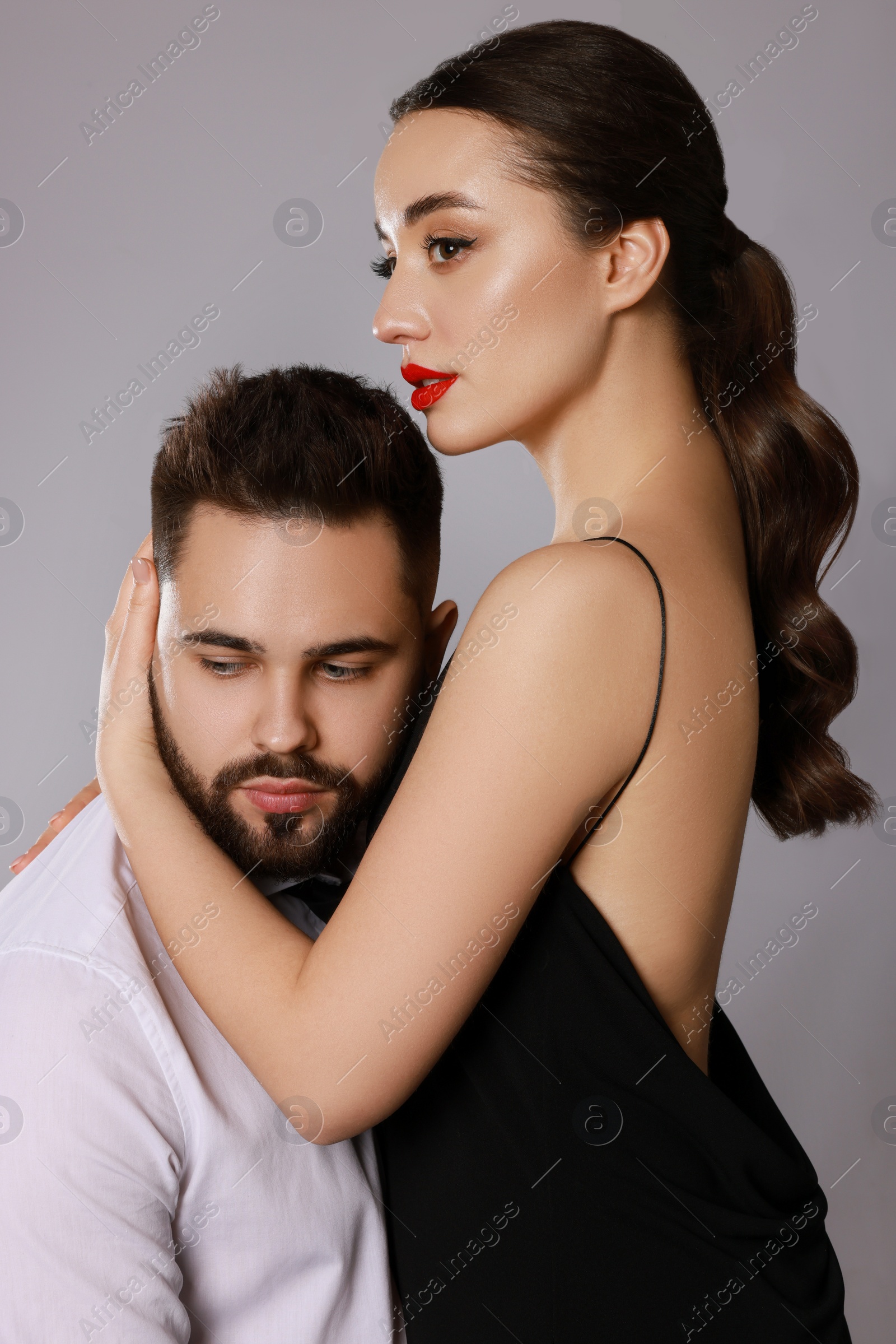 Photo of Handsome bearded man with sexy lady on grey background